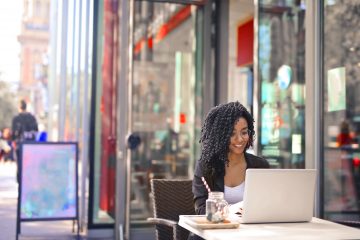 african-american-hispanic-woman-black-shirt-sitting-outside-with-laptop