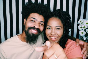 man and woman smiling with woman pointing finger into the camera